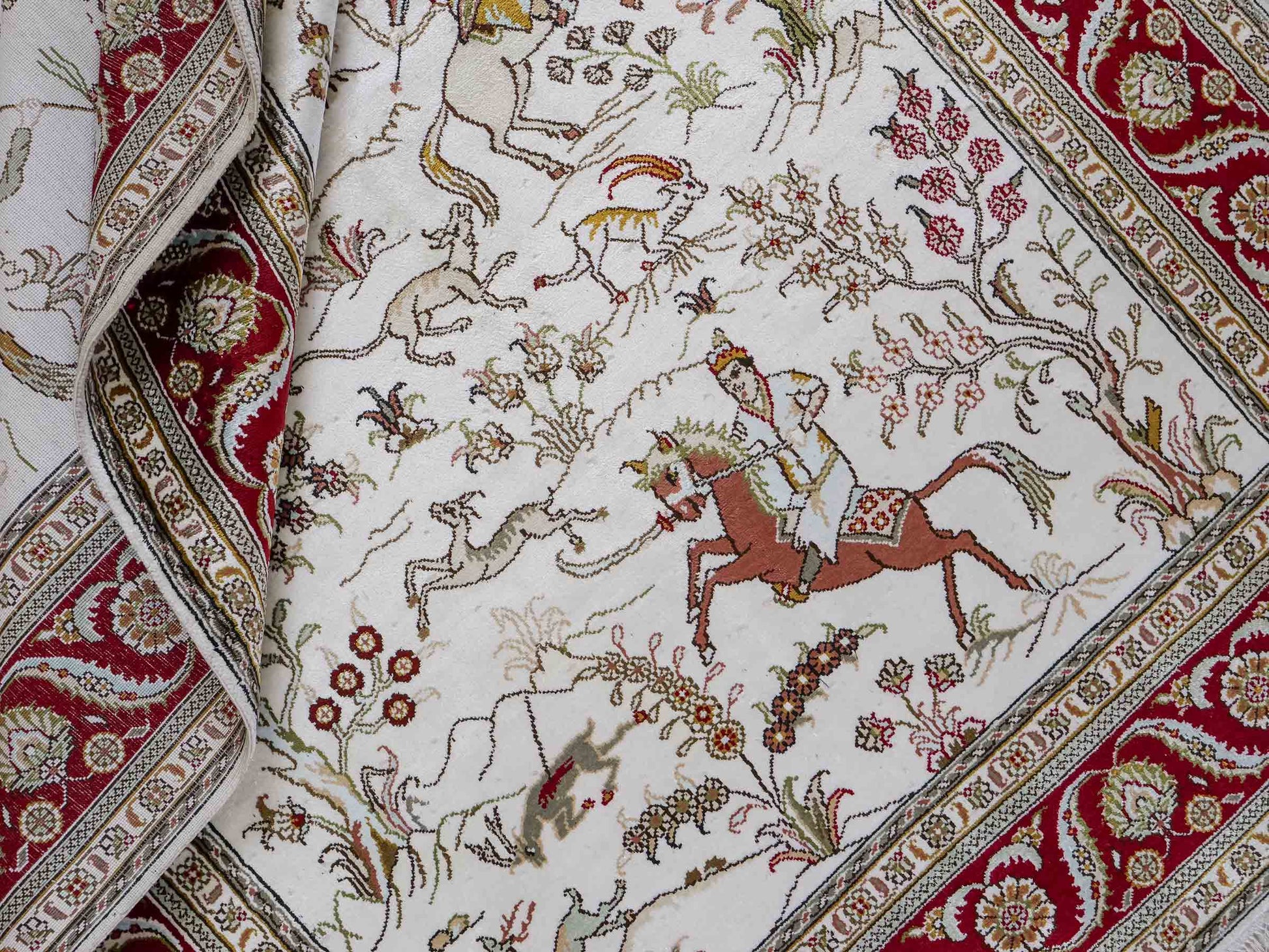 Feiner, handgeknüpfter Art Ghom aus Kunstseide. Ursprung China. Größe: 185 x 122 cm. Hauptfarben: Weiß, Creme, Rot. Vertrieb durch JUPITER Intl.