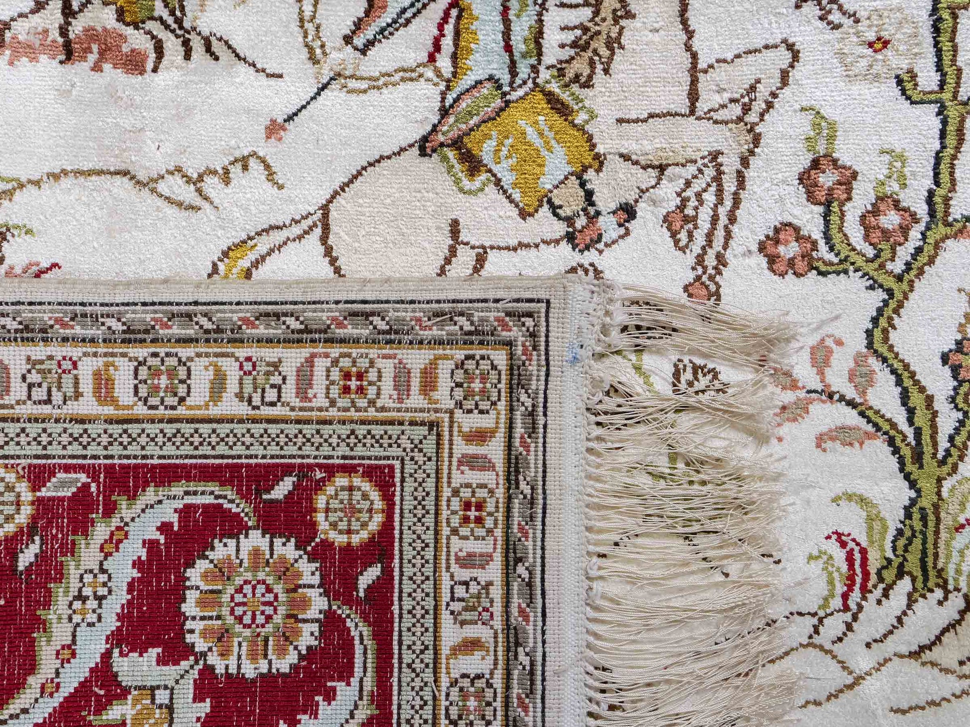 Feiner, handgeknüpfter Art Ghom aus Kunstseide. Ursprung China. Größe: 185 x 122 cm. Hauptfarben: Weiß, Creme, Rot. Vertrieb durch JUPITER Intl.