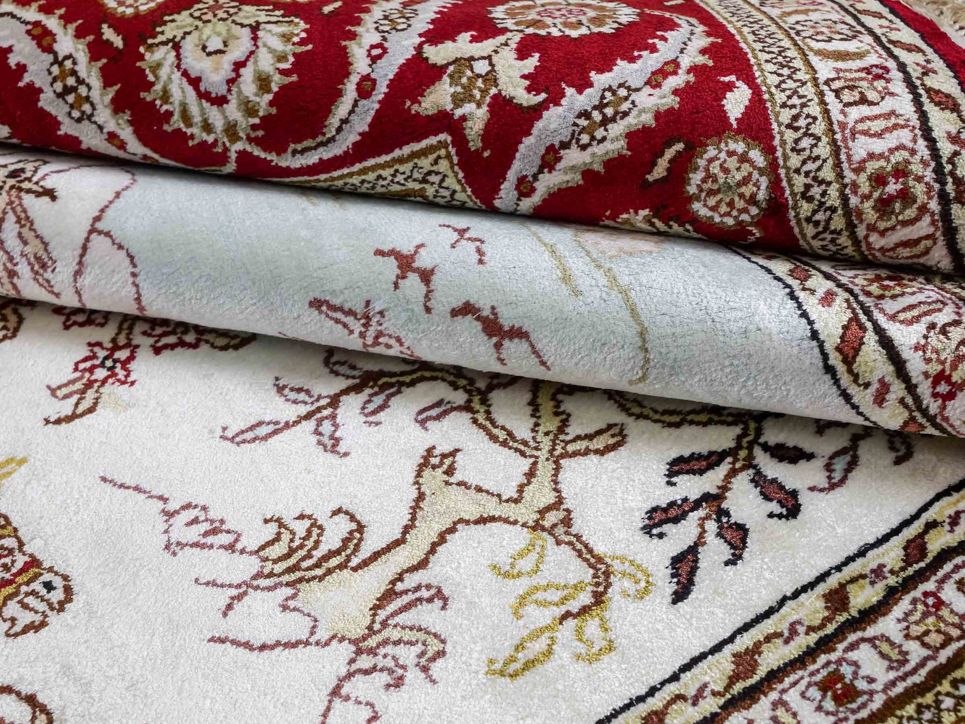 Feiner, handgeknüpfter Art Ghom aus Kunstseide. Ursprung China. Größe: 185 x 124 cm. Hauptfarben: Weiß, Creme, Rot. Vertrieb durch JUPITER Intl.