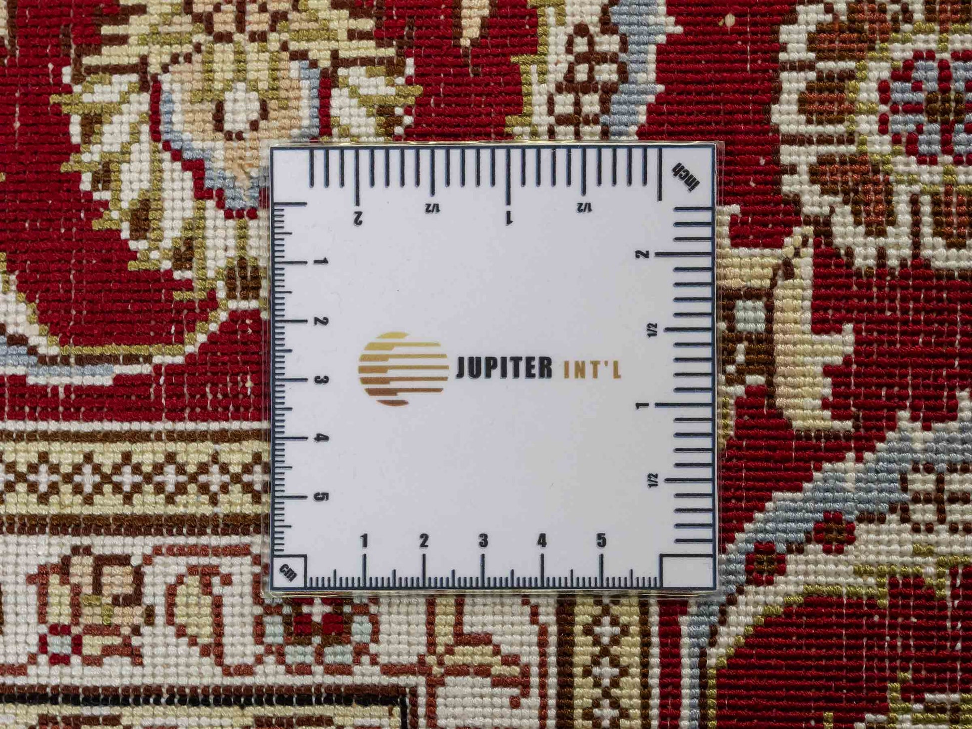 Feiner, handgeknüpfter Art Ghom aus Kunstseide. Ursprung China. Größe: 185 x 124 cm. Hauptfarben: Weiß, Creme, Rot. Vertrieb durch JUPITER Intl.