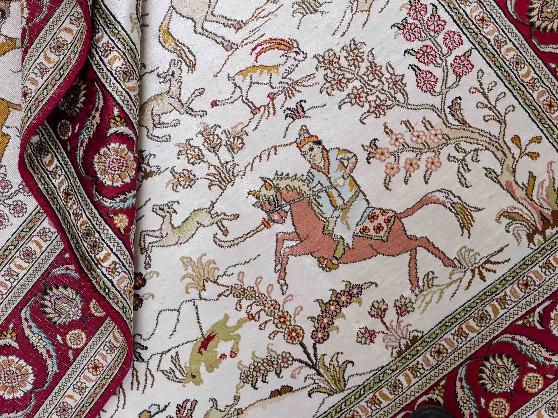Feiner, handgeknüpfter Art Ghom aus Kunstseide. Ursprung China. Größe: 185 x 124 cm. Hauptfarben: Weiß, Creme, Rot. Vertrieb durch JUPITER Intl.