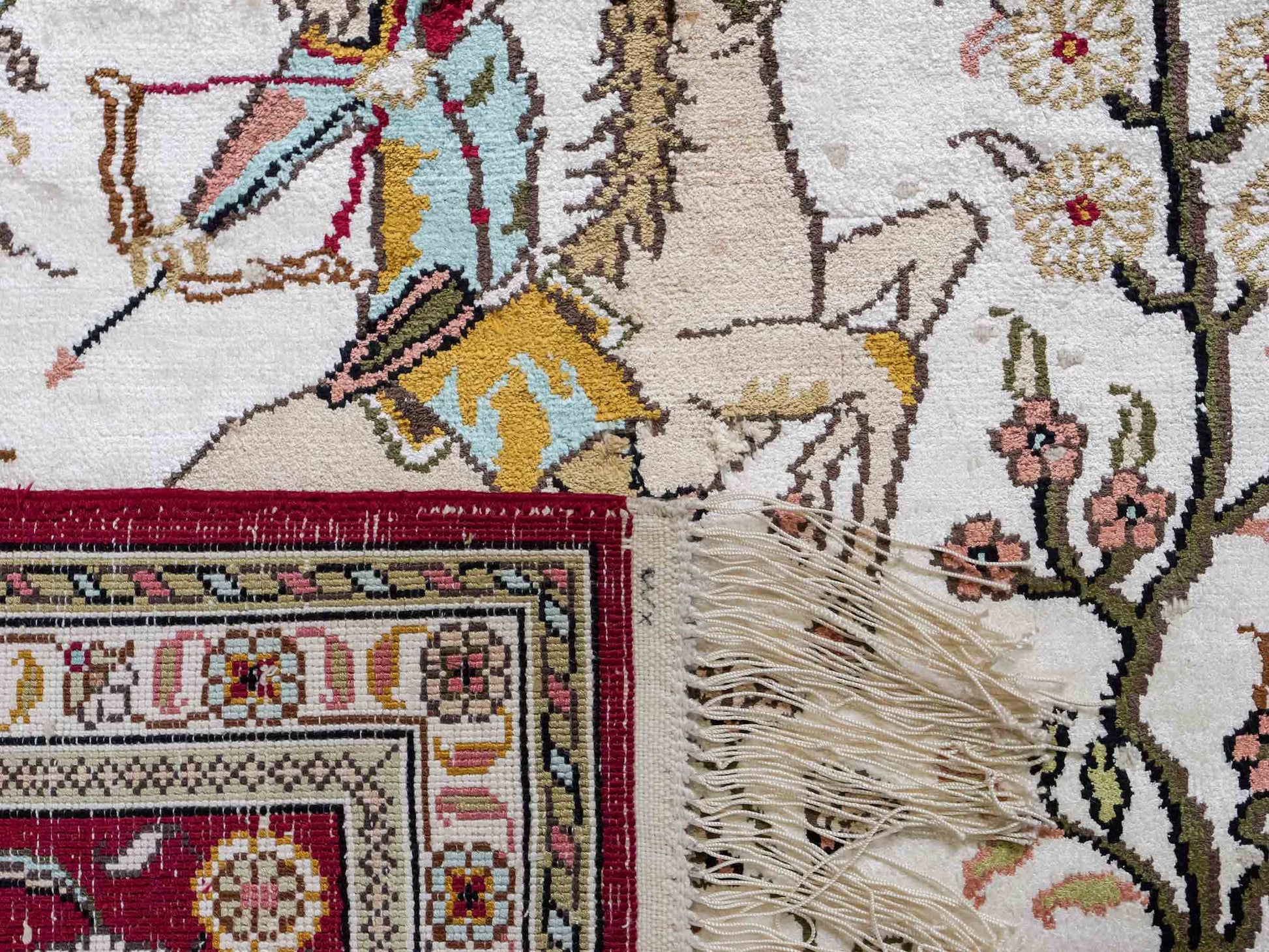 Feiner, handgeknüpfter Art Ghom aus Kunstseide. Ursprung China. Größe: 185 x 124 cm. Hauptfarben: Weiß, Creme, Rot. Vertrieb durch JUPITER Intl.