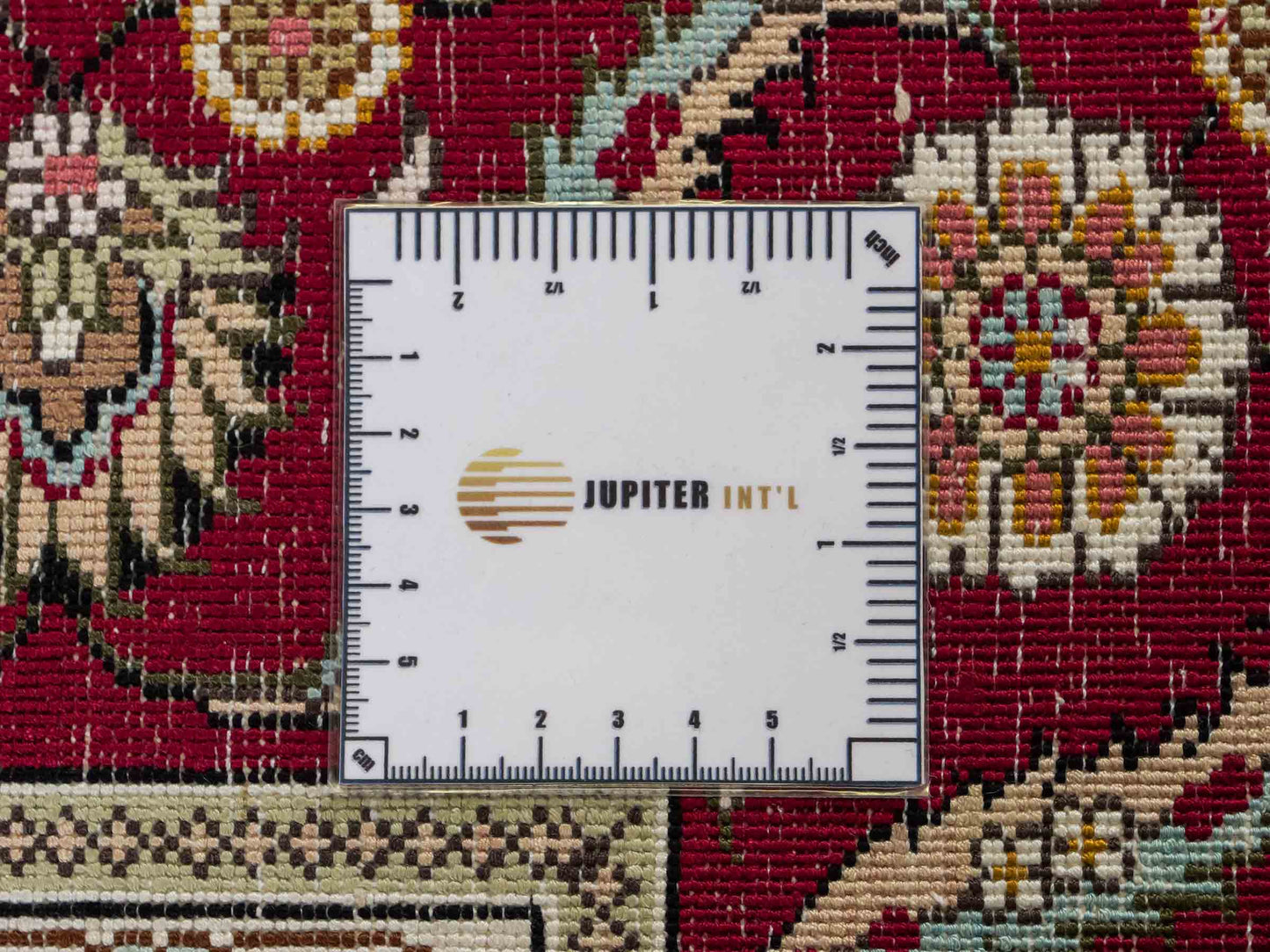 Feiner, handgeknüpfter Art Ghom aus Kunstseide. Ursprung China. Größe: 185 x 124 cm. Hauptfarben: Weiß, Creme, Rot. Vertrieb durch JUPITER Intl.