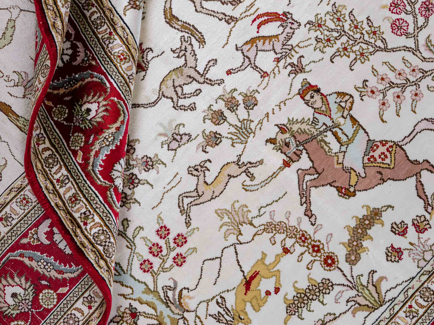 Feiner, handgeknüpfter Art Ghom aus Kunstseide. Ursprung China. Größe: 185 x 126 cm. Hauptfarben: Weiß, Creme, Rot. Vertrieb durch JUPITER Intl.