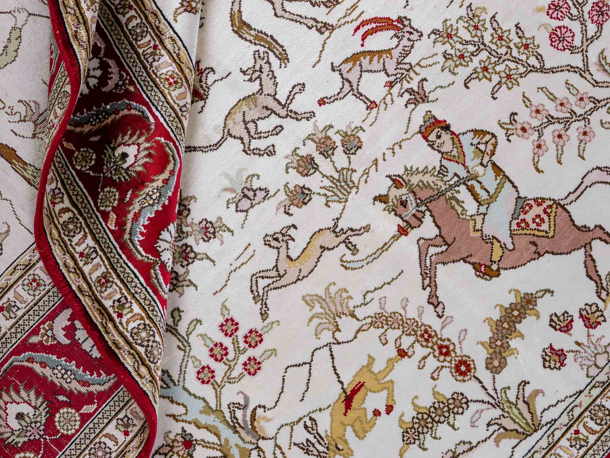 Feiner, handgeknüpfter Art Ghom aus Kunstseide. Ursprung China. Größe: 185 x 126 cm. Hauptfarben: Weiß, Creme, Rot. Vertrieb durch JUPITER Intl.