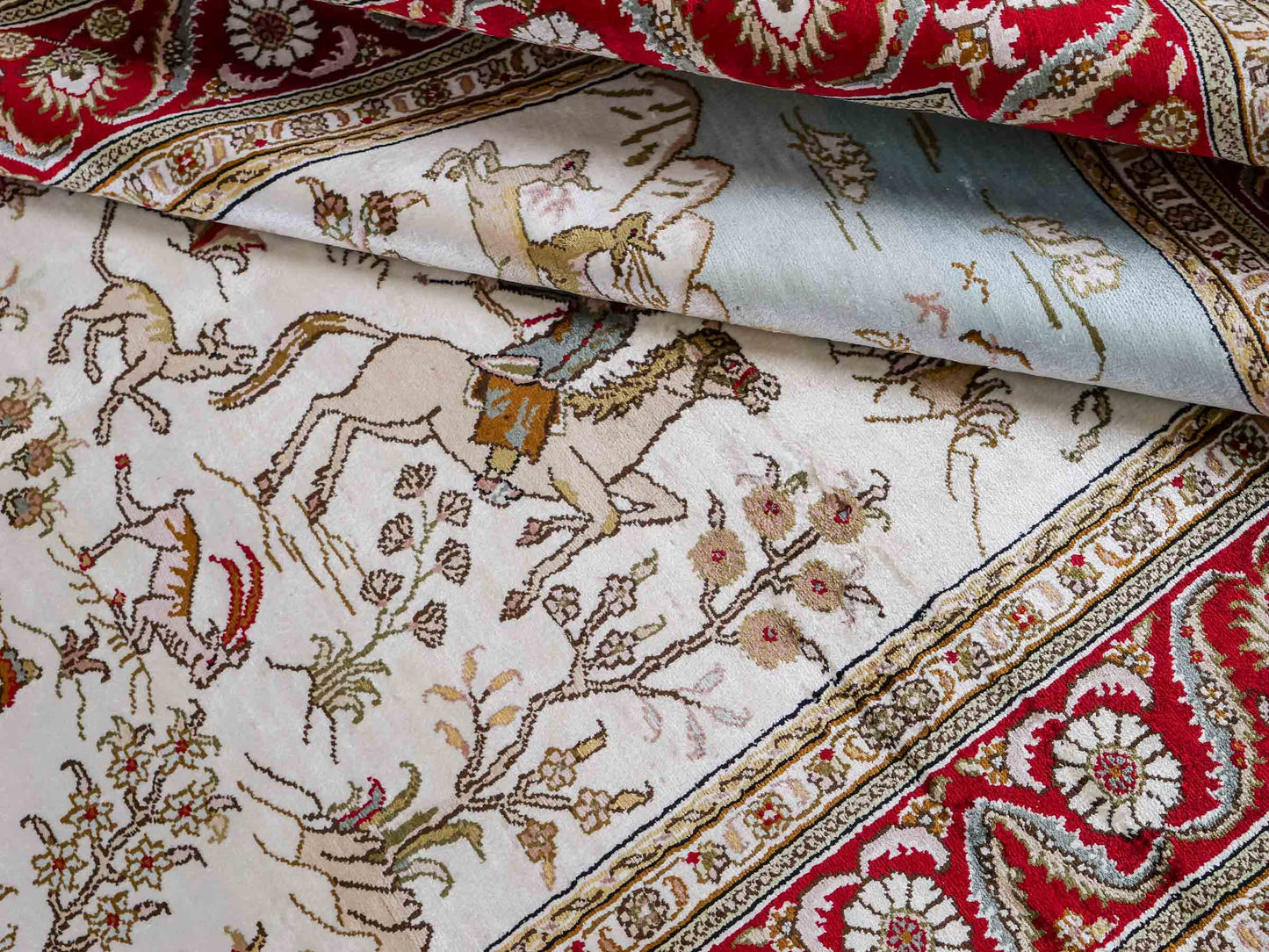 Feiner, handgeknüpfter Art Ghom aus Kunstseide. Ursprung China. Größe: 185 x 126 cm. Hauptfarben: Weiß, Creme, Rot. Vertrieb durch JUPITER Intl.