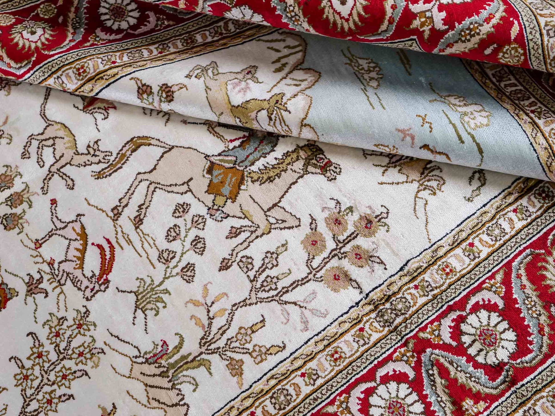 Feiner, handgeknüpfter Art Ghom aus Kunstseide. Ursprung China. Größe: 185 x 126 cm. Hauptfarben: Weiß, Creme, Rot. Vertrieb durch JUPITER Intl.