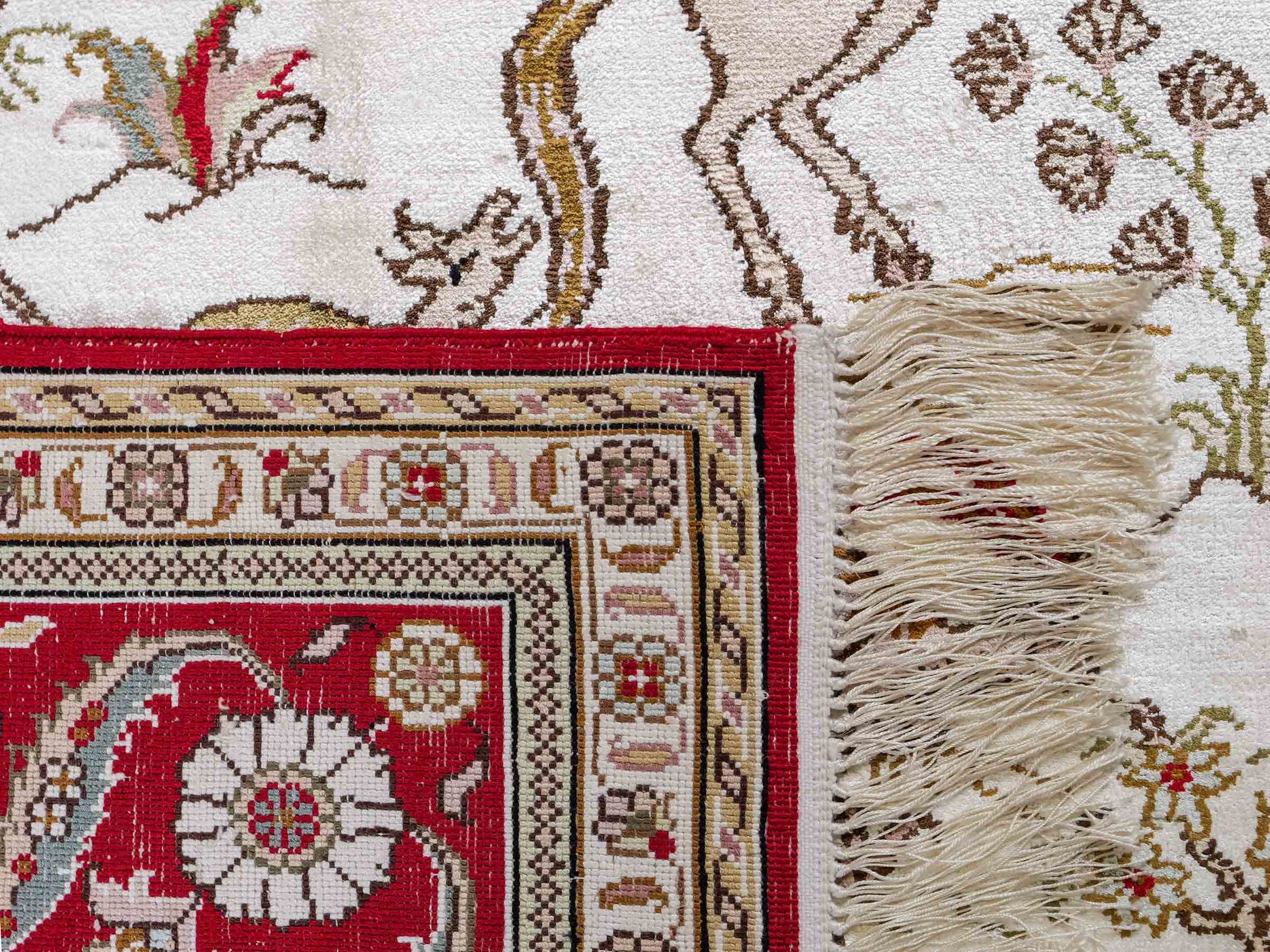 Feiner, handgeknüpfter Art Ghom aus Kunstseide. Ursprung China. Größe: 185 x 126 cm. Hauptfarben: Weiß, Creme, Rot. Vertrieb durch JUPITER Intl.
