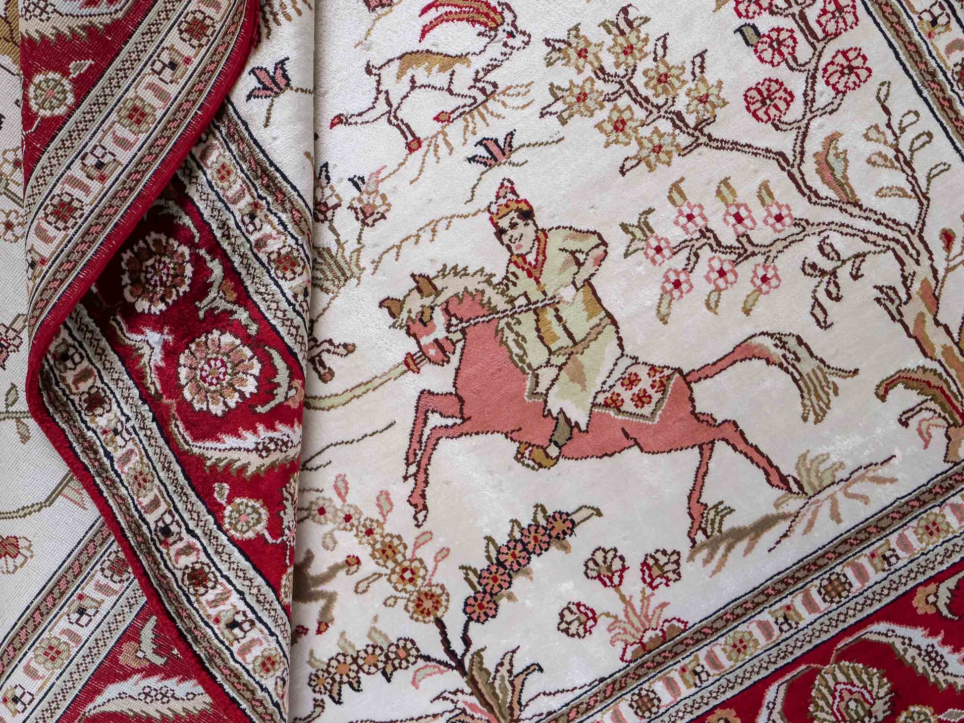 Feiner, handgeknüpfter Art Ghom aus Kunstseide. Ursprung China. Größe: 186 x 124 cm. Hauptfarben: Weiß, Creme, Rot. Vertrieb durch JUPITER Intl.