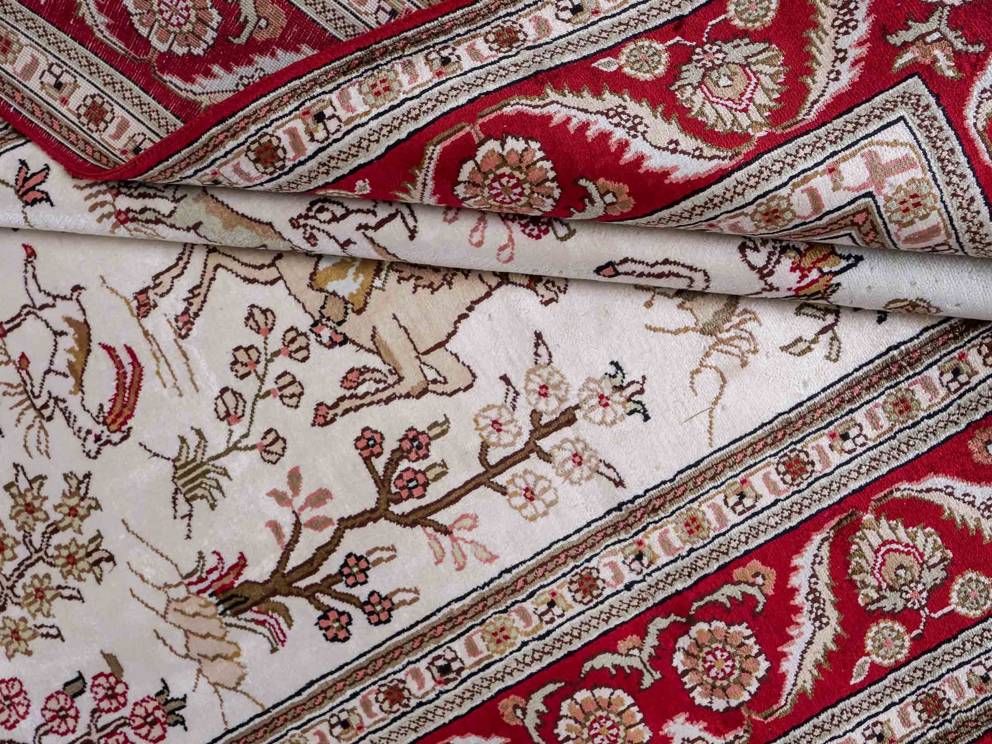 Feiner, handgeknüpfter Art Ghom aus Kunstseide. Ursprung China. Größe: 186 x 124 cm. Hauptfarben: Weiß, Creme, Rot. Vertrieb durch JUPITER Intl.