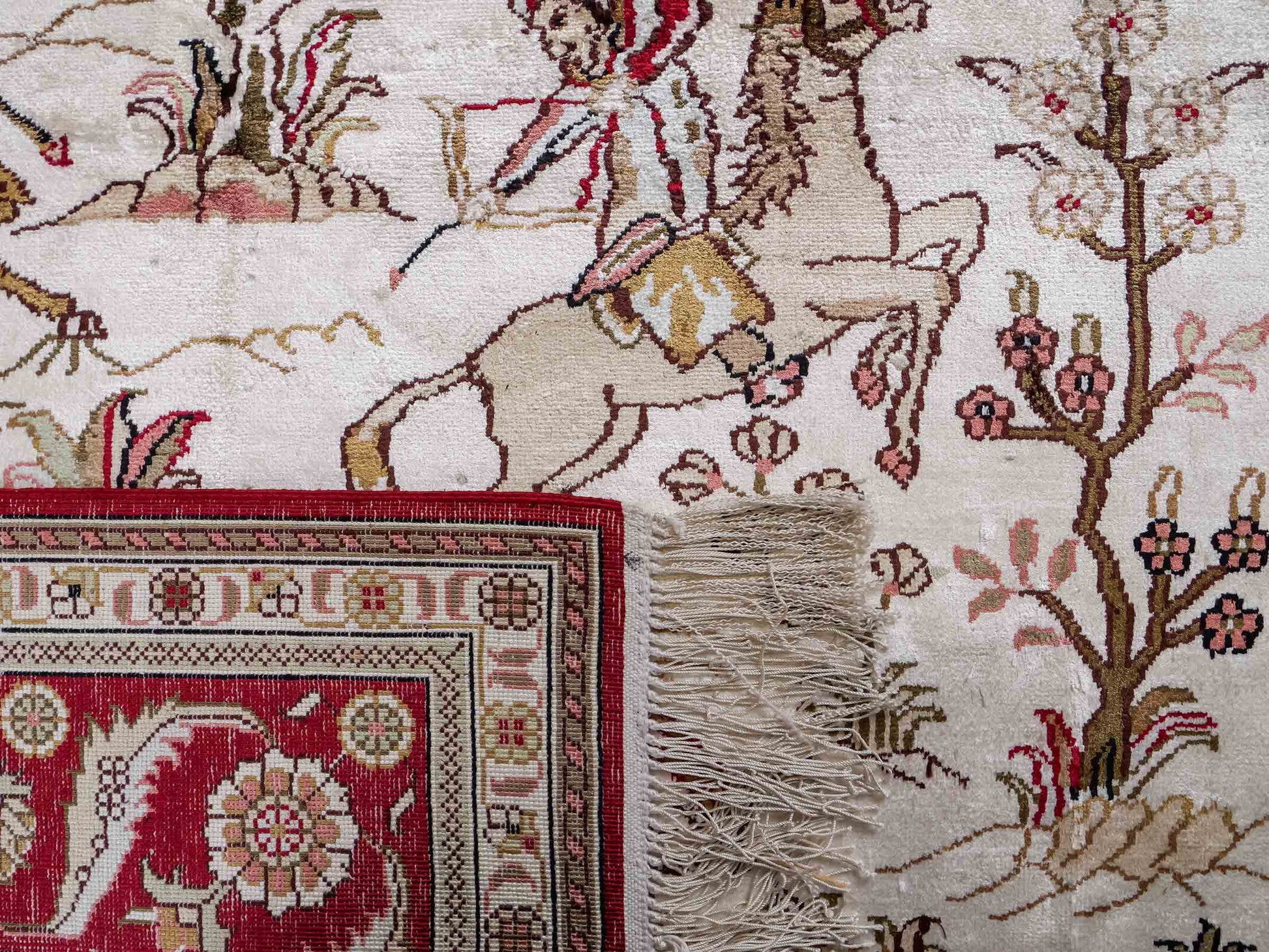 Feiner, handgeknüpfter Art Ghom aus Kunstseide. Ursprung China. Größe: 186 x 124 cm. Hauptfarben: Weiß, Creme, Rot. Vertrieb durch JUPITER Intl.