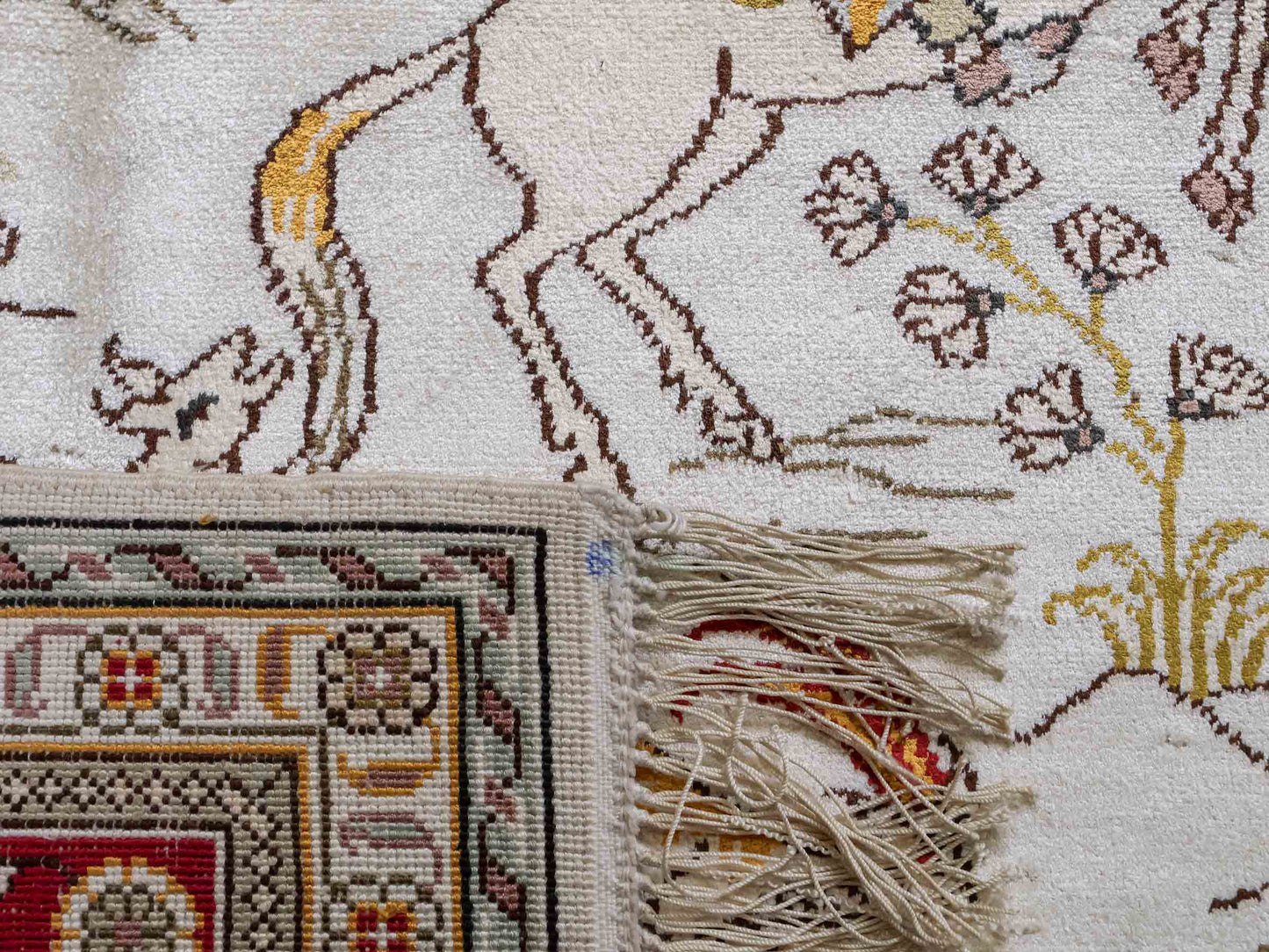 Feiner, handgeknüpfter Art Ghom aus Kunstseide. Ursprung China. Größe: 187 x 125 cm. Hauptfarben: Weiß, Creme, Rot. Vertrieb durch JUPITER Intl.