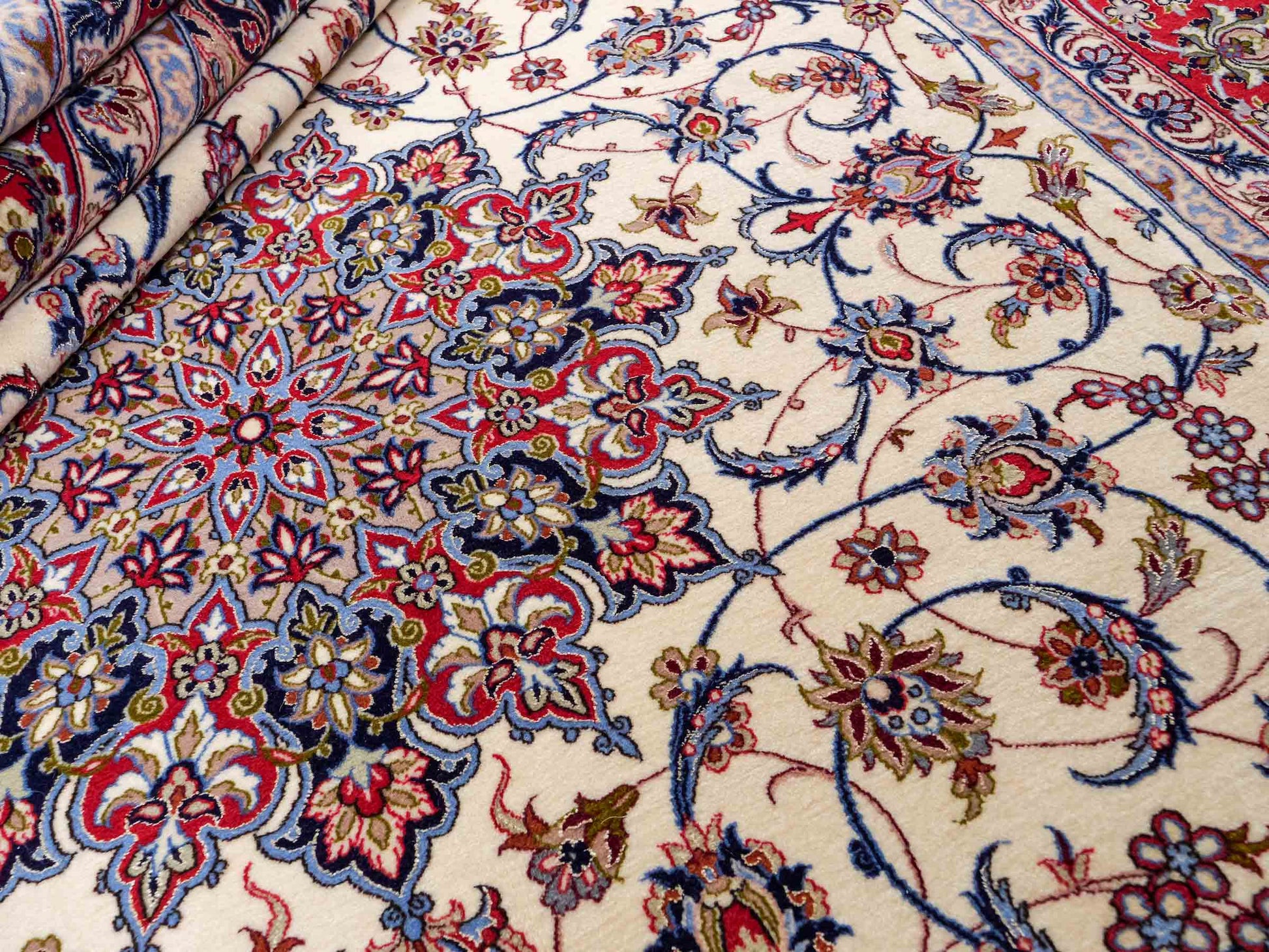 Sehr feiner, handgeknüpfter Isfahan Perserteppich aus Wolle mit Seide von Khademi. Farbe: Cremeweiß, rot, blau. Größe: 312 x 207 cm. Vertrieb durch JUPITER Intl.