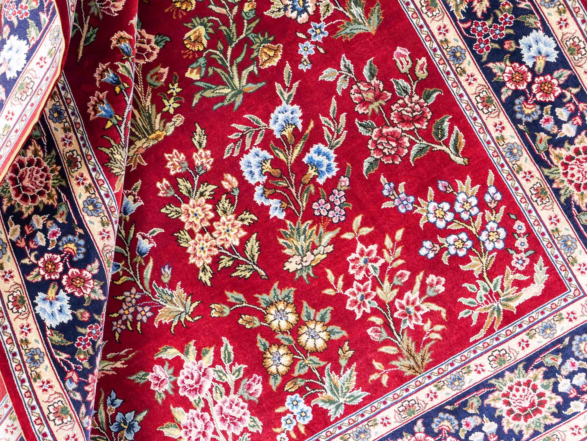 Sehr feiner, handgeknüpfter Khademi Orientteppich mit Ghom Design aus reiner Seide, rot, blau. 143x94 cm. Vertrieb durch Jupiter Intl.