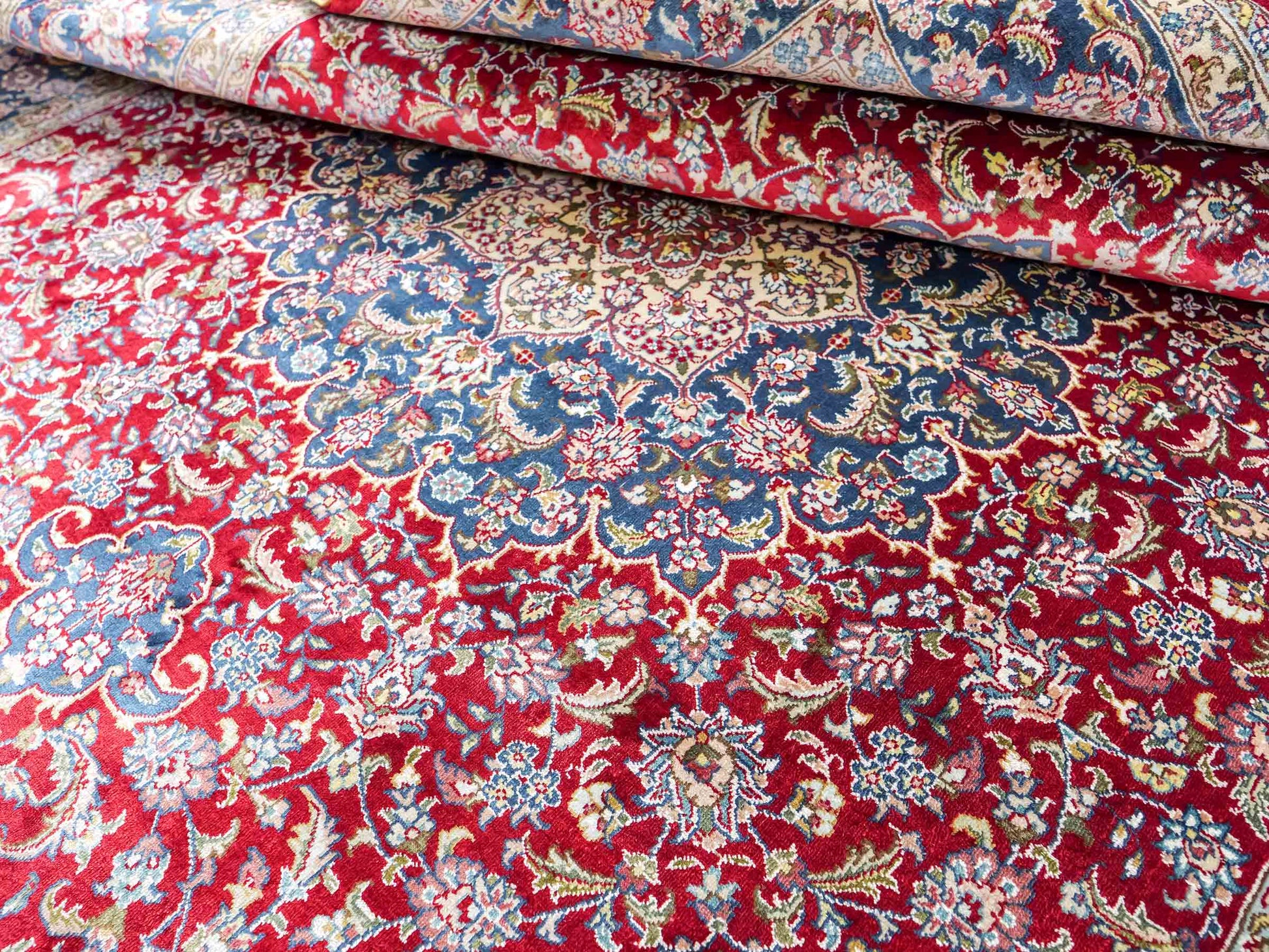Sehr feiner, handgeknüpfter Khademi Orientteppich mit Ghom Design aus reiner Seide, rot, blau, creme. 187x126 cm. Vertrieb durch Jupiter Intl.