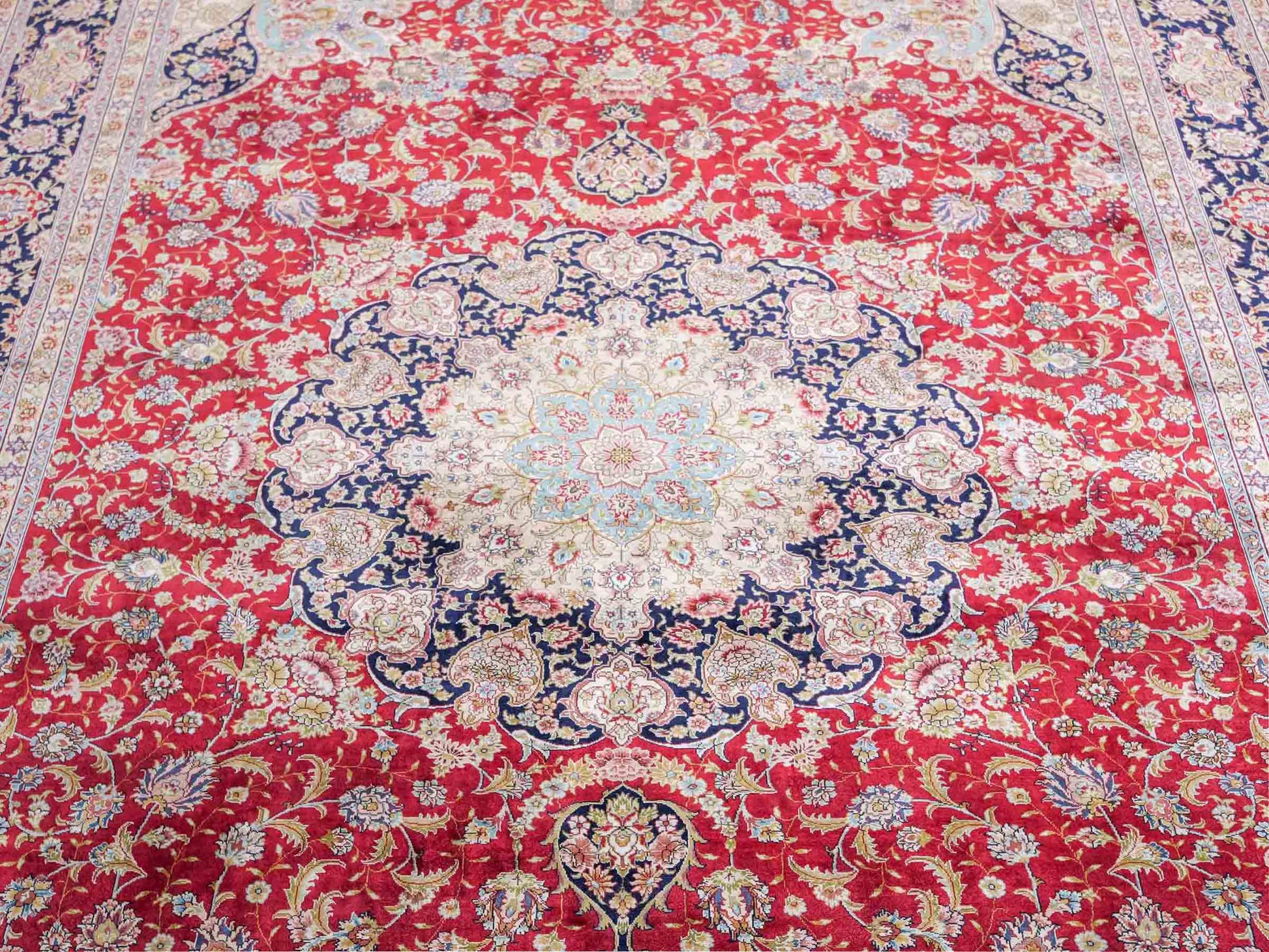 Sehr feiner, handgeknüpfter Khademi Orientteppich mit Ghom Design aus reiner Seide, rot, blau, creme. 278x186 cm. Vertrieb durch Jupiter Intl.