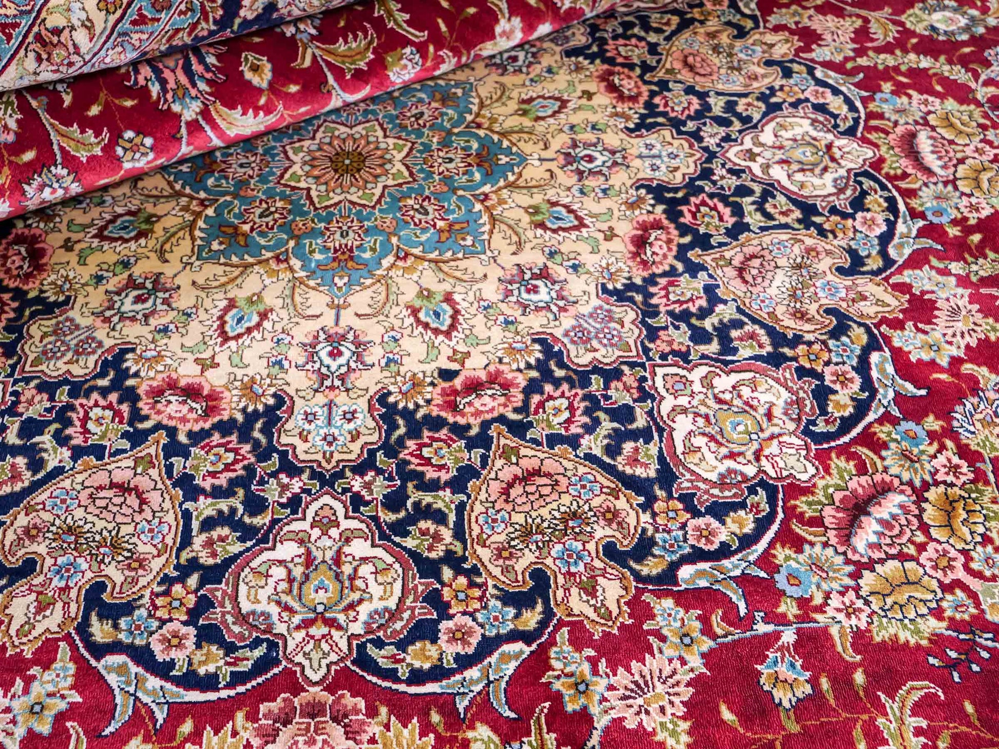 Sehr feiner, handgeknüpfter Khademi Orientteppich mit Ghom Design aus reiner Seide, rot, blau, creme. 278x186 cm. Vertrieb durch Jupiter Intl.