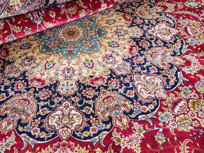 Sehr feiner, handgeknüpfter Khademi Orientteppich mit Ghom Design aus reiner Seide, rot, blau, creme. 278x186 cm. Vertrieb durch Jupiter Intl.