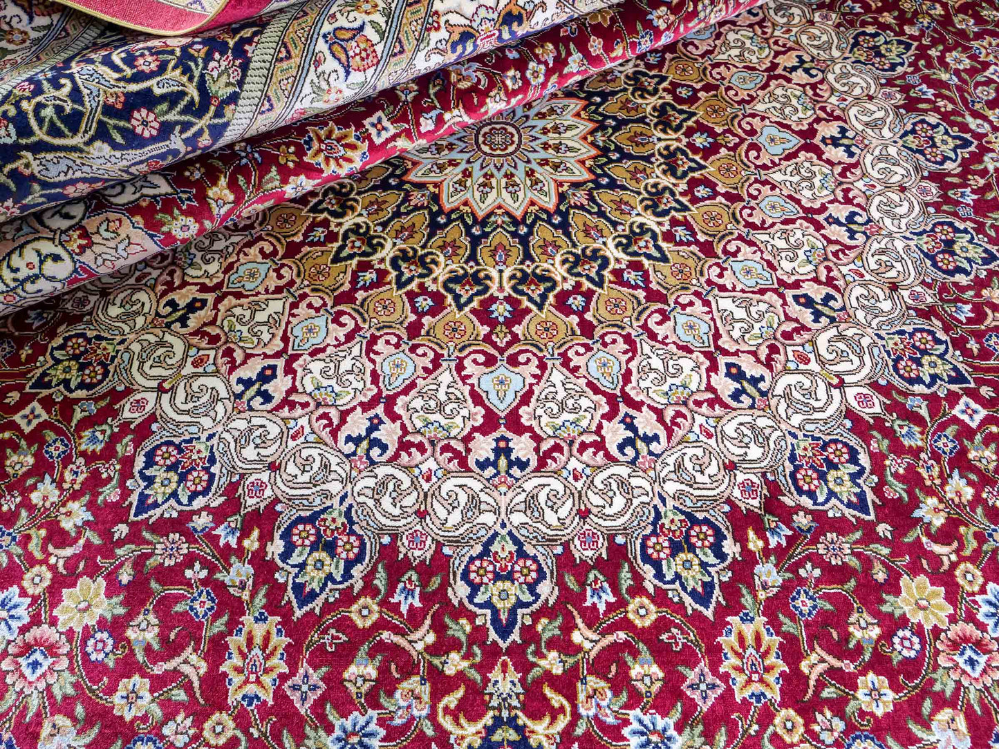 Sehr feiner, handgeknüpfter Khademi Orientteppich mit Ghom Design aus reiner Seide, rot, blau, creme. 305x206 cm. Vertrieb durch Jupiter Intl.