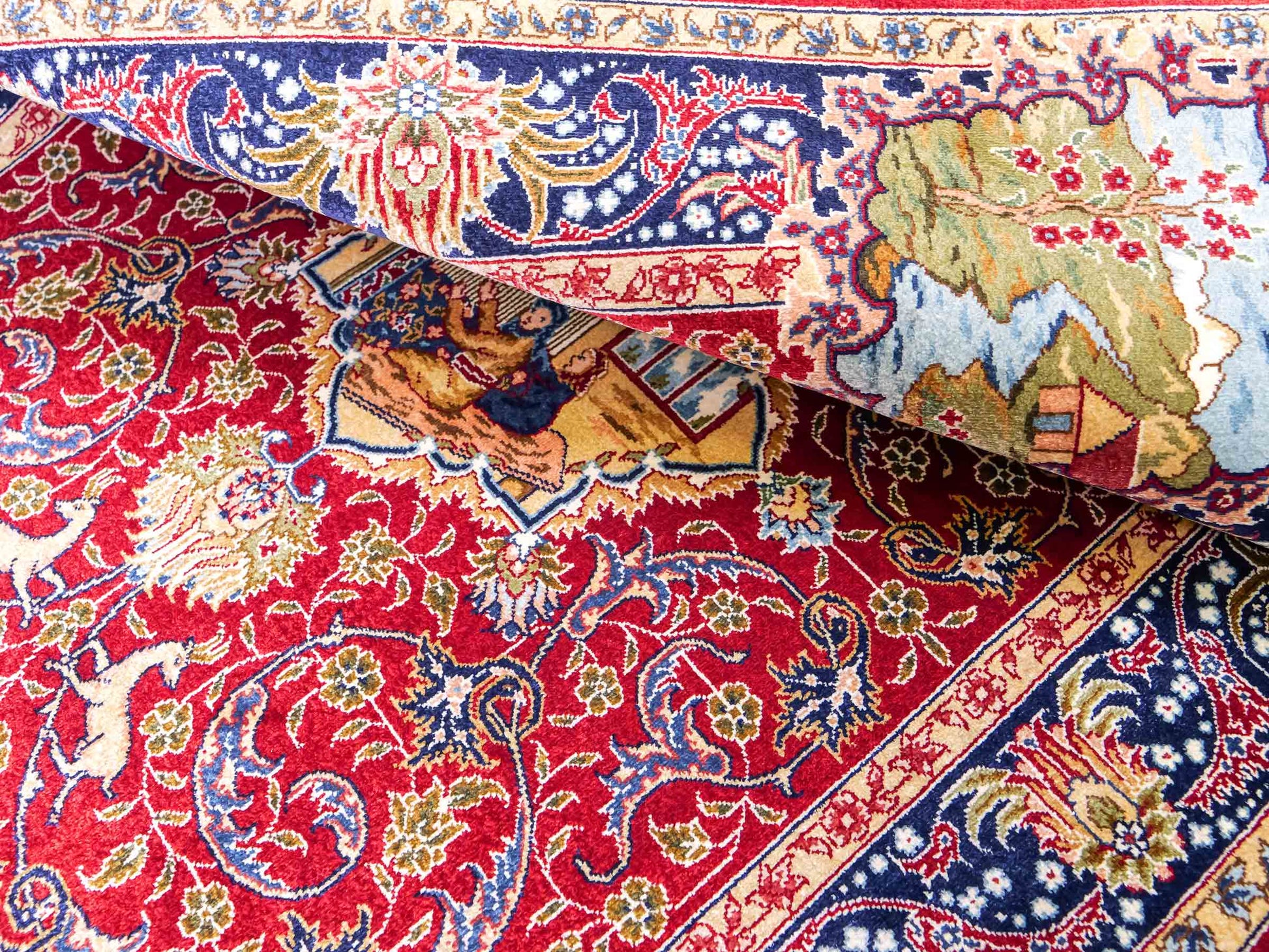 Sehr feiner, handgeknüpfter Khademi Orientteppich mit Ghom Design aus reiner Seide, rot, blau. 93x63 cm. Vertrieb durch Jupiter Intl.