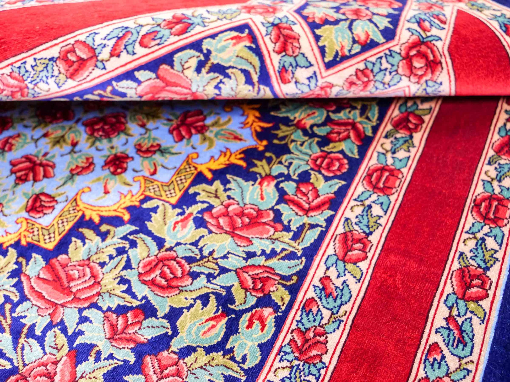 Sehr feiner, handgeknüpfter Khademi Orientteppich mit Ghom Design aus reiner Seide, blau, rot, grün. 94x63 cm. Vertrieb durch Jupiter Intl.